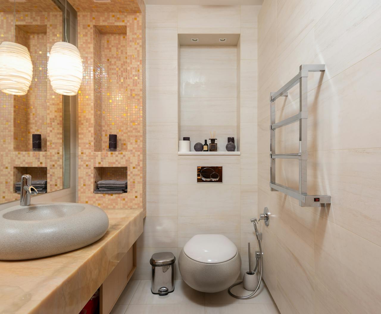 Interior of small light bathroom with ceramic sink and wall mounted toilet in modern apartment
